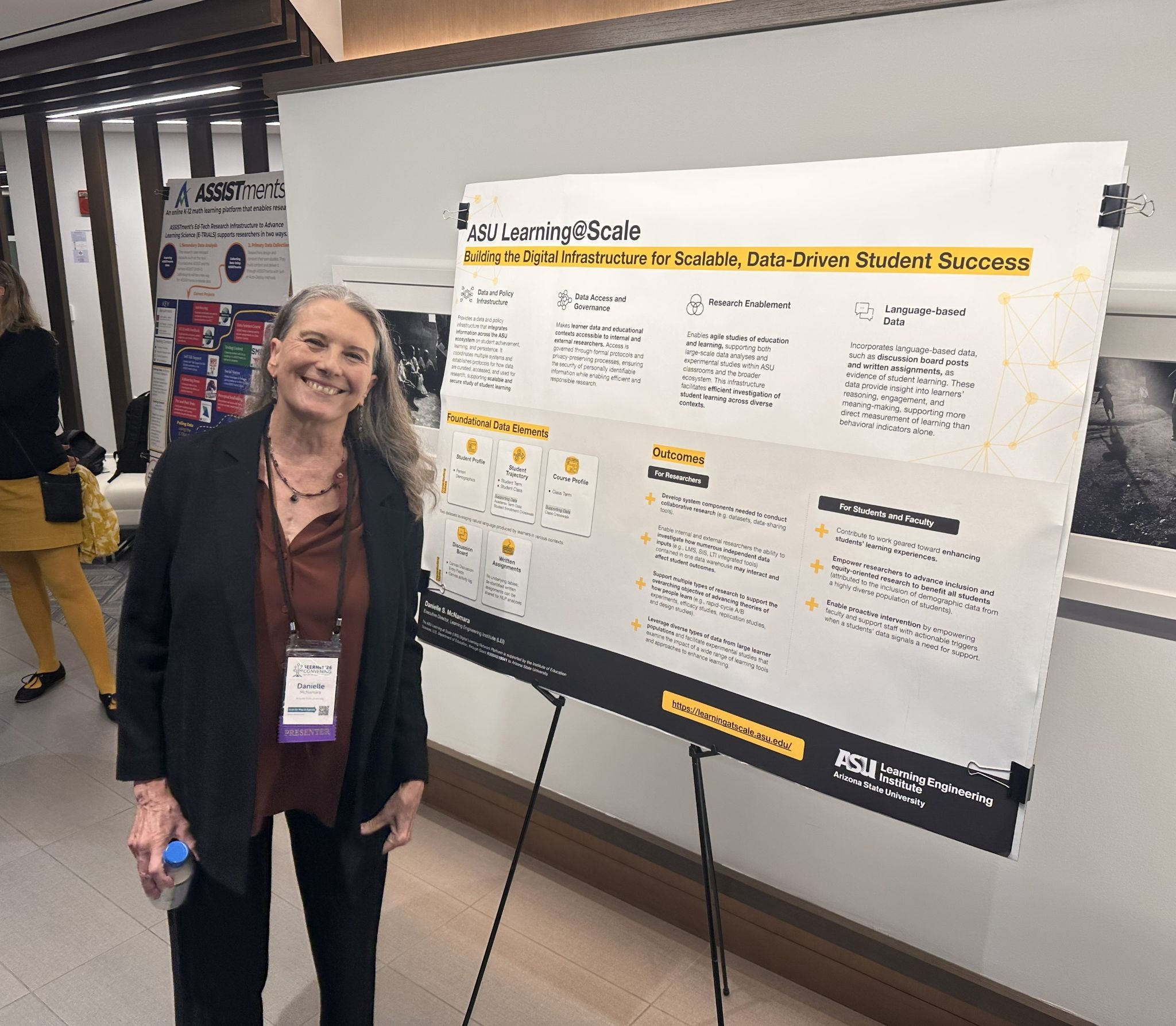 A woman standing next to a research poster
